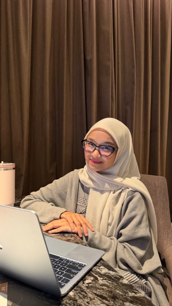 Shofina Azzahra, Founder RumaKerja, bekerja dengan laptop
